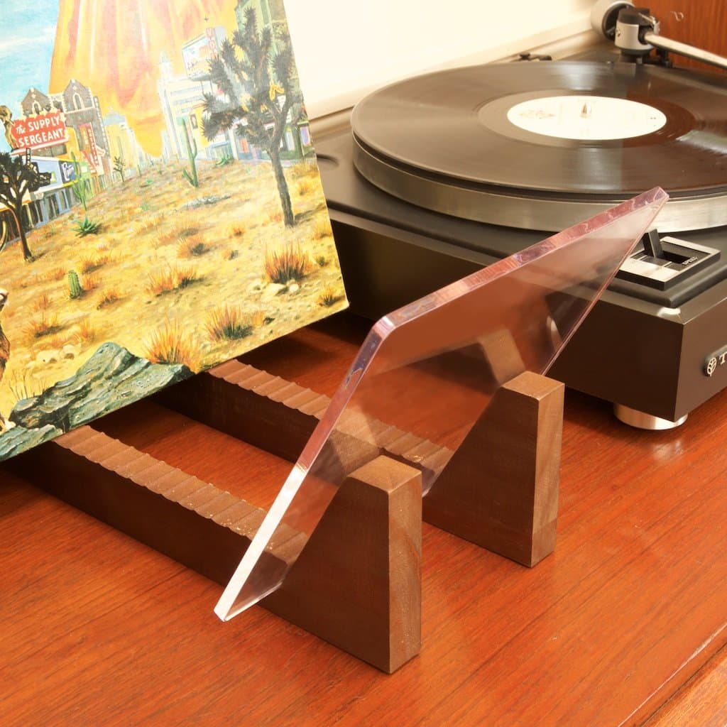KAIU vinyl record storage holder with clear acrylic ends and wood base.